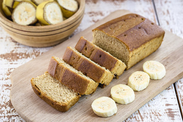 vegan banana bread, with banana slices on the side, on a white table. Healthy vegan life concept.