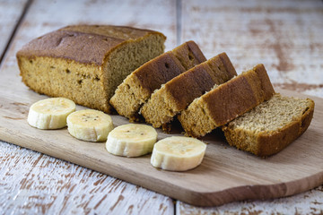 Gluten-free vegan bread and no animal products. Vegetarian bread with oatmeal, banana flavor, on a rustic white table, sliced ​​and ready to serve.