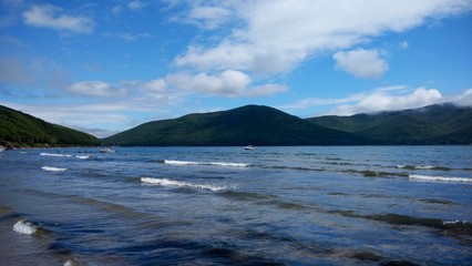 view of the summer sea with waves and mountains