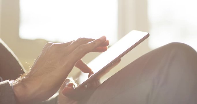 4k businessman using a touchscreen tablet computer surface while internet surfing.
