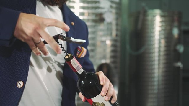 A man is opening a bottle of vine. Corkscrew opening bottle of wine. 4K
