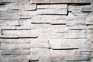 Stone decorative wall of gray color in the sunlight