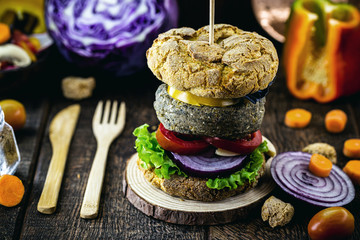Tasty and vegan hamburger of rice and vegetables, on rustic wooden background. Vegan food without meat or animal products.