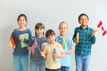 Little pupils of language school on light background