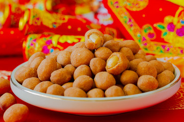 Peanut snack in a plate red background close up
