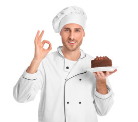 Male confectioner with tasty dessert showing OK gesture on white background