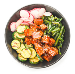 Bowl with tasty tofu cheese and vegetables on white background