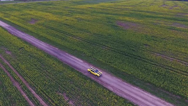 Yellow With Black Stripes Classic Ford Consul Rides On A Gravel Road. 4K Aerial Footage