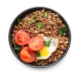 Bowl of tasty buckwheat porridge, tomato and eggs on white background