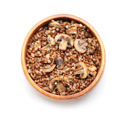 Bowl of tasty buckwheat porridge and mushrooms on white background