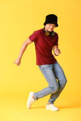 African-American teenager dancing against color background