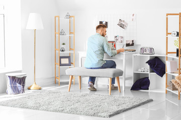 Young male designer working at home