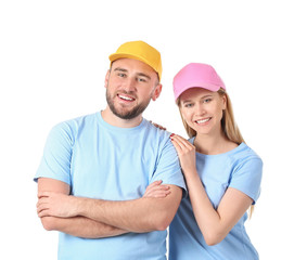 Young couple in stylish caps on white background