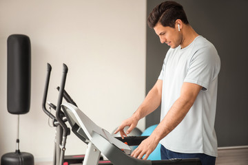 Young man training on treadmill in gym