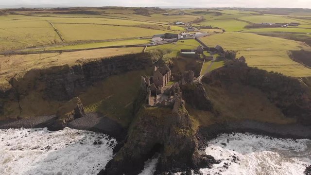 Point of interest orbiting aerial drone shot of famous Dunluce Castle ruins, Game of Thrones shooting location on Antrim Coast, Northern Ireland