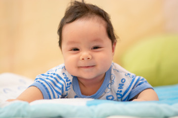 Happy baby boy  playing  on bed