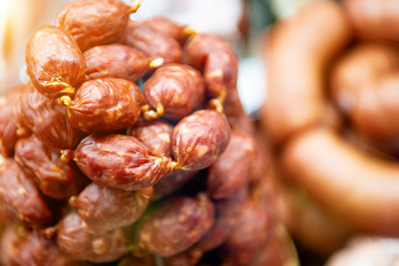 A bunch of small smoked sausages. Butcher shop window.