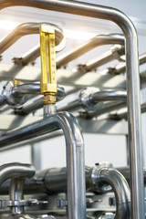 Industrial stainless steel piping connected by special nuts.