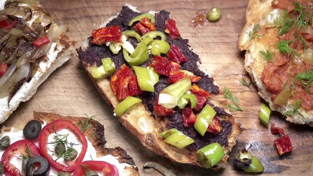 Panning on colorful brushetta sandwiches on wooden background.