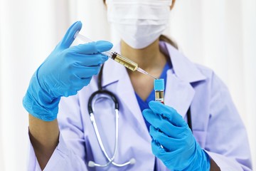 Hand holding syringe and vaccine treatment from Coronavirus covid-19 infection.