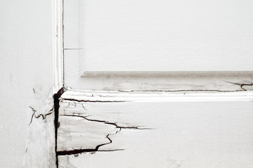 The wood door with damage, old broken wooden white door ,Concept for dirty, destroyed, abandoned