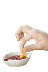 Hand holding french fries dipped in tomato sauce in a paper cup on a white background. French Fries highly popular in America. Is a diet that is high in fat unhealthy.