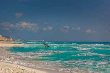 Big Pelican flies over the sea against a blue sky.