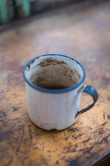 Old Enamel Mug on a worn wooden table © RubberHorse