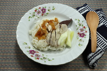Traditional boiled sliced chicken and fried chicken topping on cooked rice. Famous street food menu in Asia. Fast and easy meal in breakfast. Hainanese chicken rice on the plate concept. 
