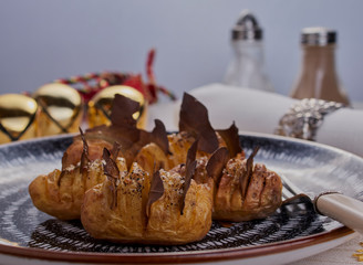 Spicy new potatoes with bay leaves,there is some condiments and Christmas decorations in the background.