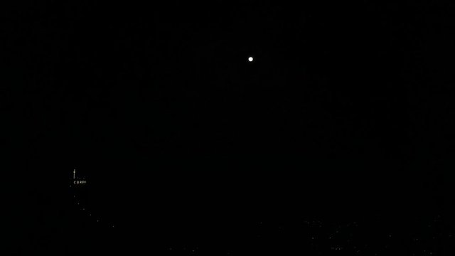Coron City sign and catholic cross monument left on Mt. Tapyas at night with full moon on the right, Busuanga Island Philippines, Aerial close in shot