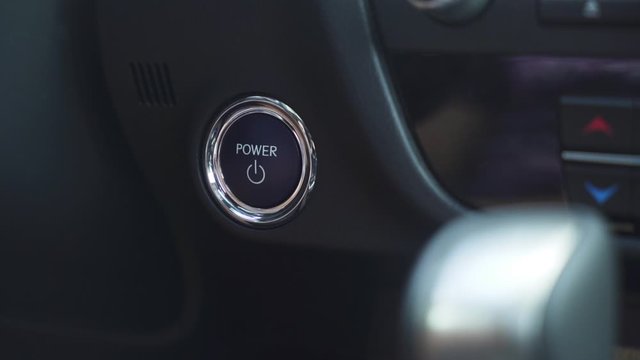 Shot of pressing start button of a car