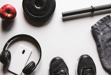 Towel, sneakers, and smartphone with headphones on a white background