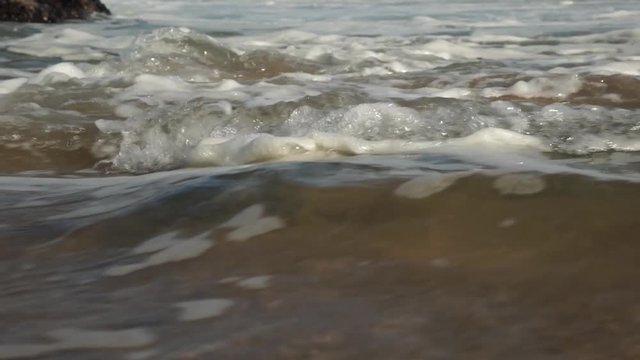 Fast moving ocean waves crashing onto rocky shore. Cresmina beach (Praia da Cresmina), Portugal. 