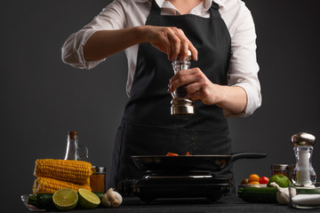 Chef cooks vegetables in a pan with shrimp. Cooking and recipe book.