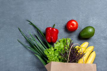 Different food in paper bag on wooden background, close up.