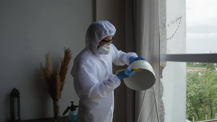 Men in virus protective suit making treatment from coronavirus, preventive measures