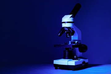 Modern microscope on color background