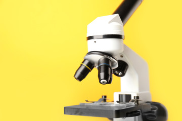Modern microscope on color background