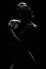 Silhouette de femme nue sous la lumière dans l& 39 obscurité