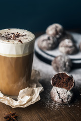 A few marble brown cookies with glass of coffee latte, star anise and powdered sugar