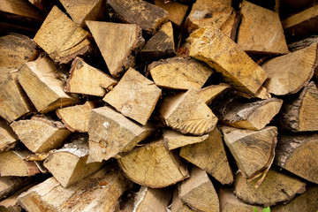 Split birch logs for the fireplace are stacked on top of each other. Wood for a picnic. Betulaceae. Firewood