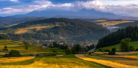 Beautiful landscape of Polish Spisz, undulating, fields on undulating hills, view of the Tatra Mountains