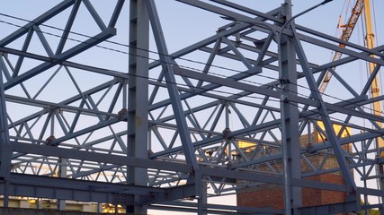 Construction of a building from metal structures. Preparation of the roof. Welding work. Joining steel beams.