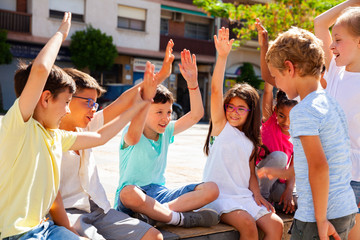 Obraz premium Group of positive children holding hands up and smiling together