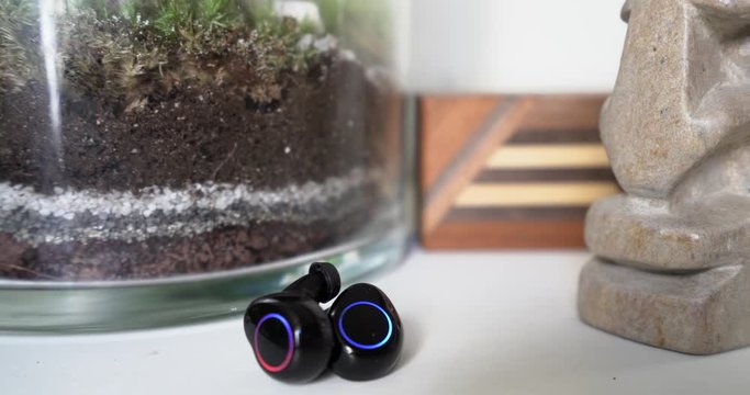 Led light changing on a set of black Bluetooth wireless earbuds, technology