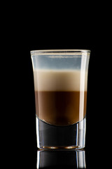 B52 coffee creamy alcohol cocktail in three layers in a shot glass on a black background