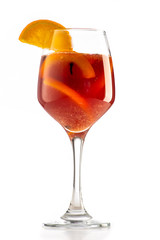 sangria or mulled wine cocktail in a glass with oranges, wine and juice on a white background