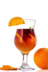 sangria or mulled wine cocktail in a glass with oranges, wine and juice on a white background