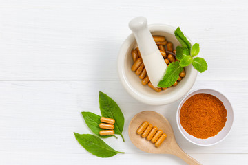 Herbal supplement in capsules with healthy medicinal plant.Alternative drug or natural pharmaceutical capsule.Medication of vitamin supplemental for care and treatment.Top view.